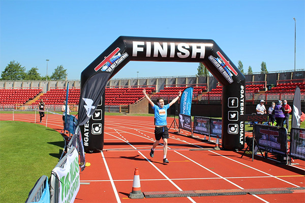 Runner crossing the finish line at Gateshead 10k