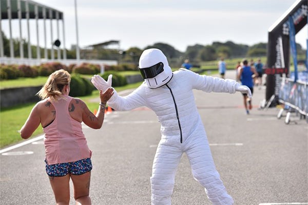 Runner interacts with an event cheer at Goodwood Motor Circuit