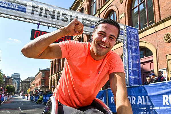 Participant in a wheelchair celebrates after the finish line