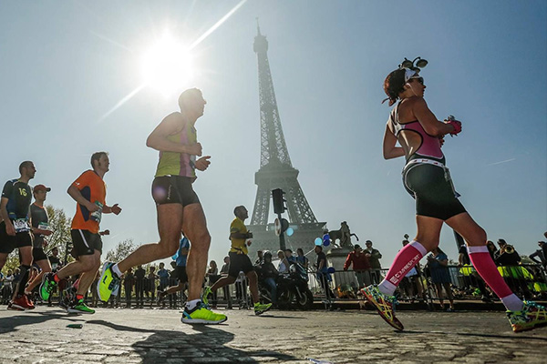 Runners run by the Eiffel Tower