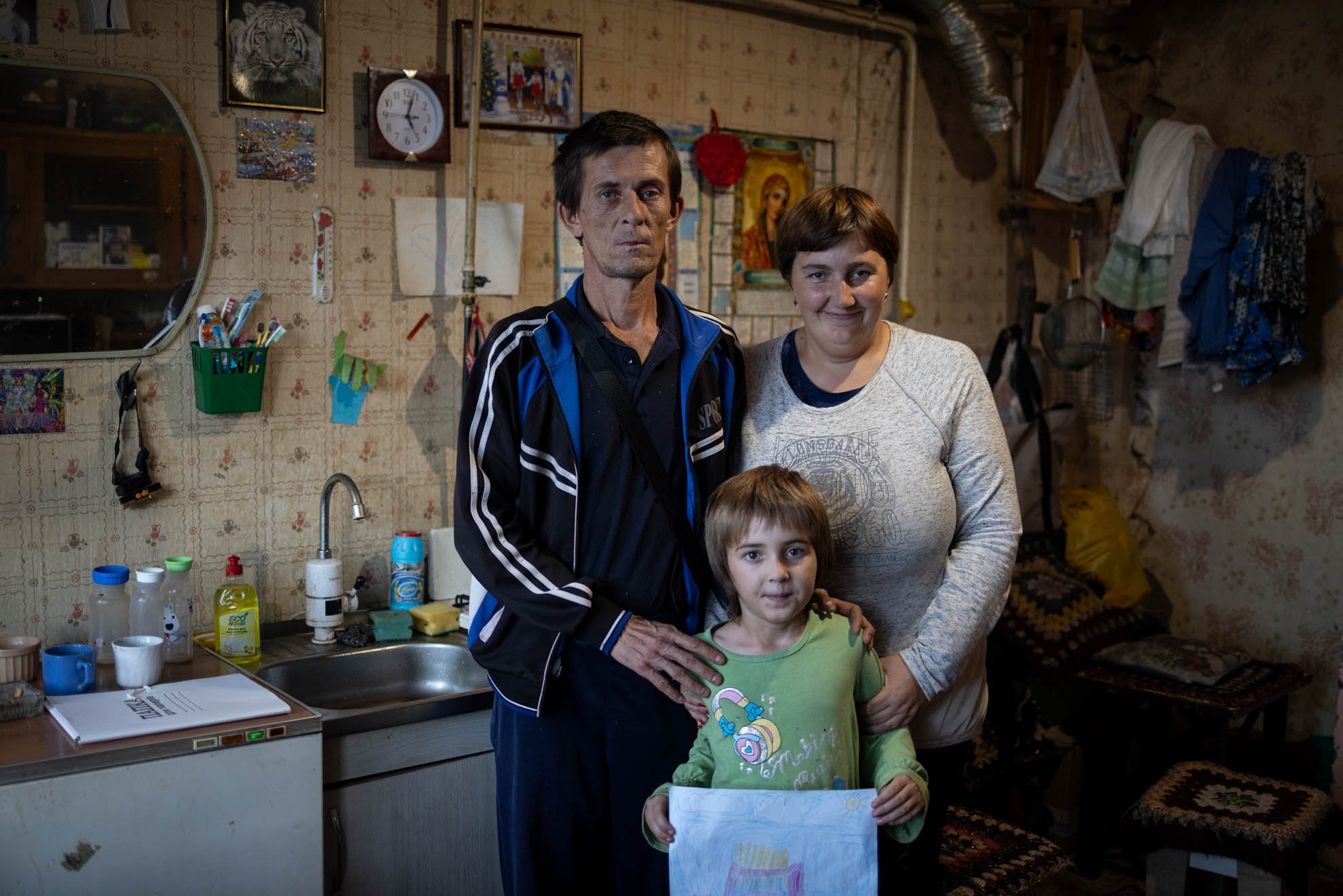 Olha and Volodymyr standing outside their house. 