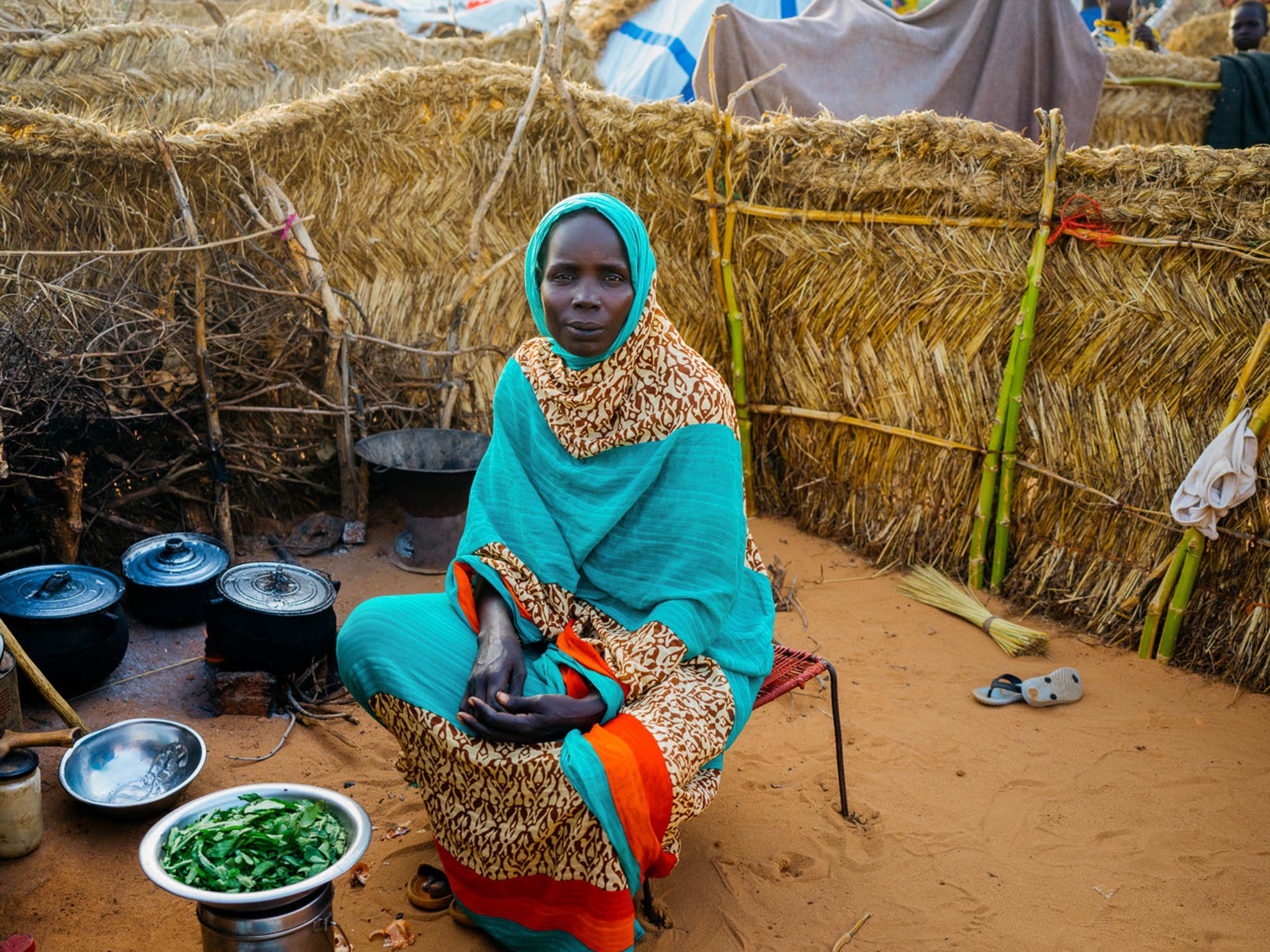 Raouba is preparing food outside her shelter