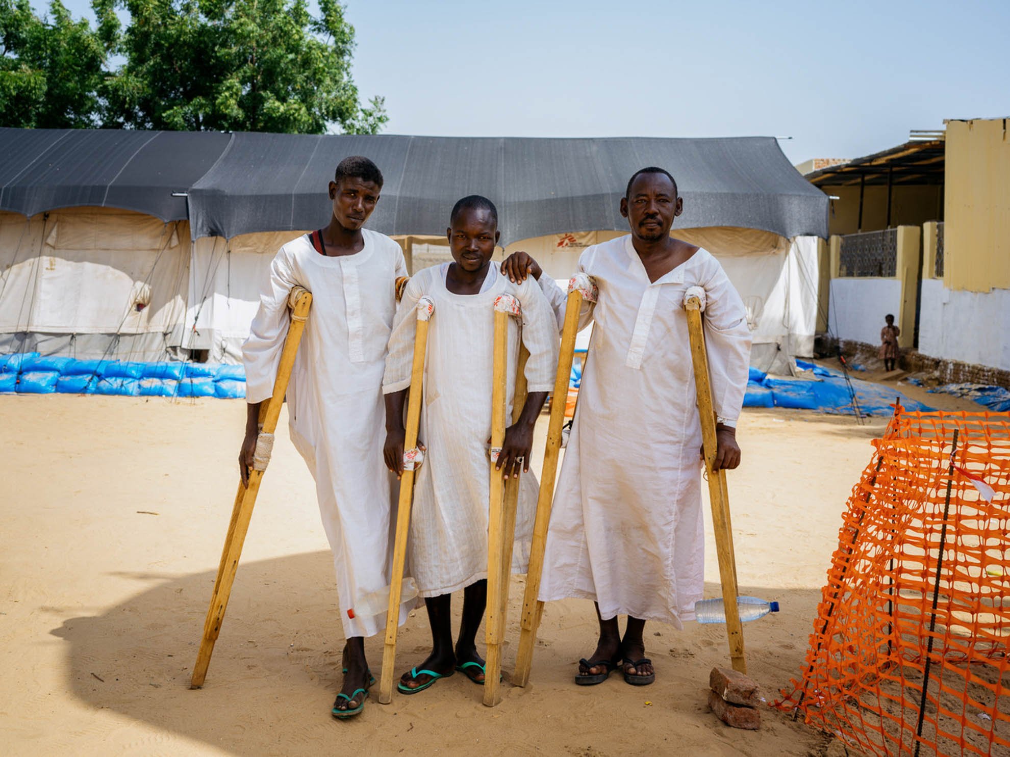 Abdulatif , Arais and Assadik standing up using crutches 