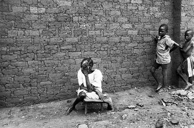 Mary sitting outside on a stool.